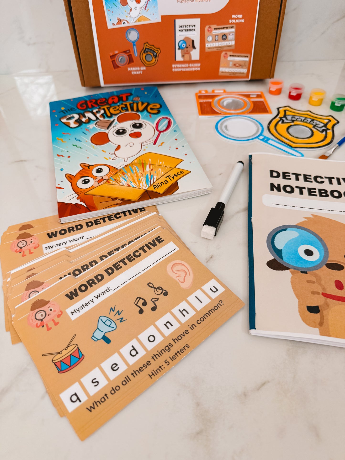 Children's educational materials including a book, notebook, and cards on a light surface.