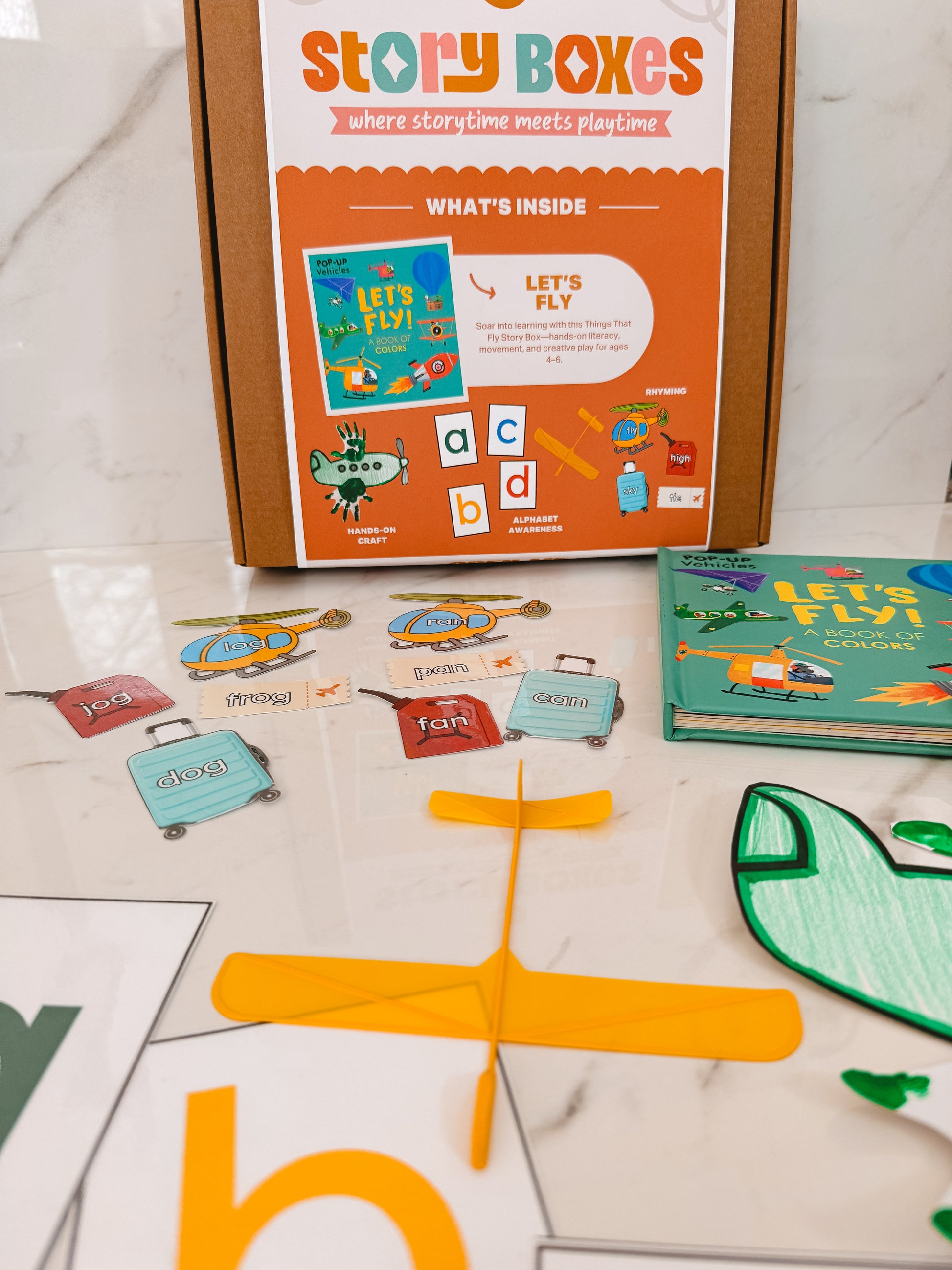 Story Boxes educational product with children's books and learning materials on a marble surface