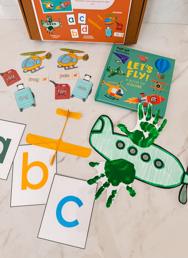 Educational children's materials including a book, cards, and handprint craft on a light surface.
