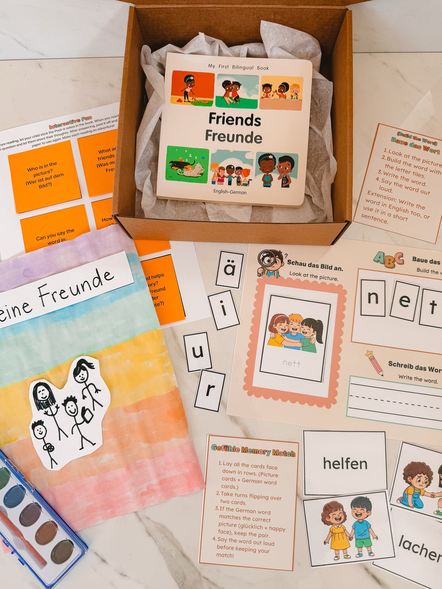 Educational materials including a book titled 'Friends' in German, flashcards, and coloring books on a wooden surface.