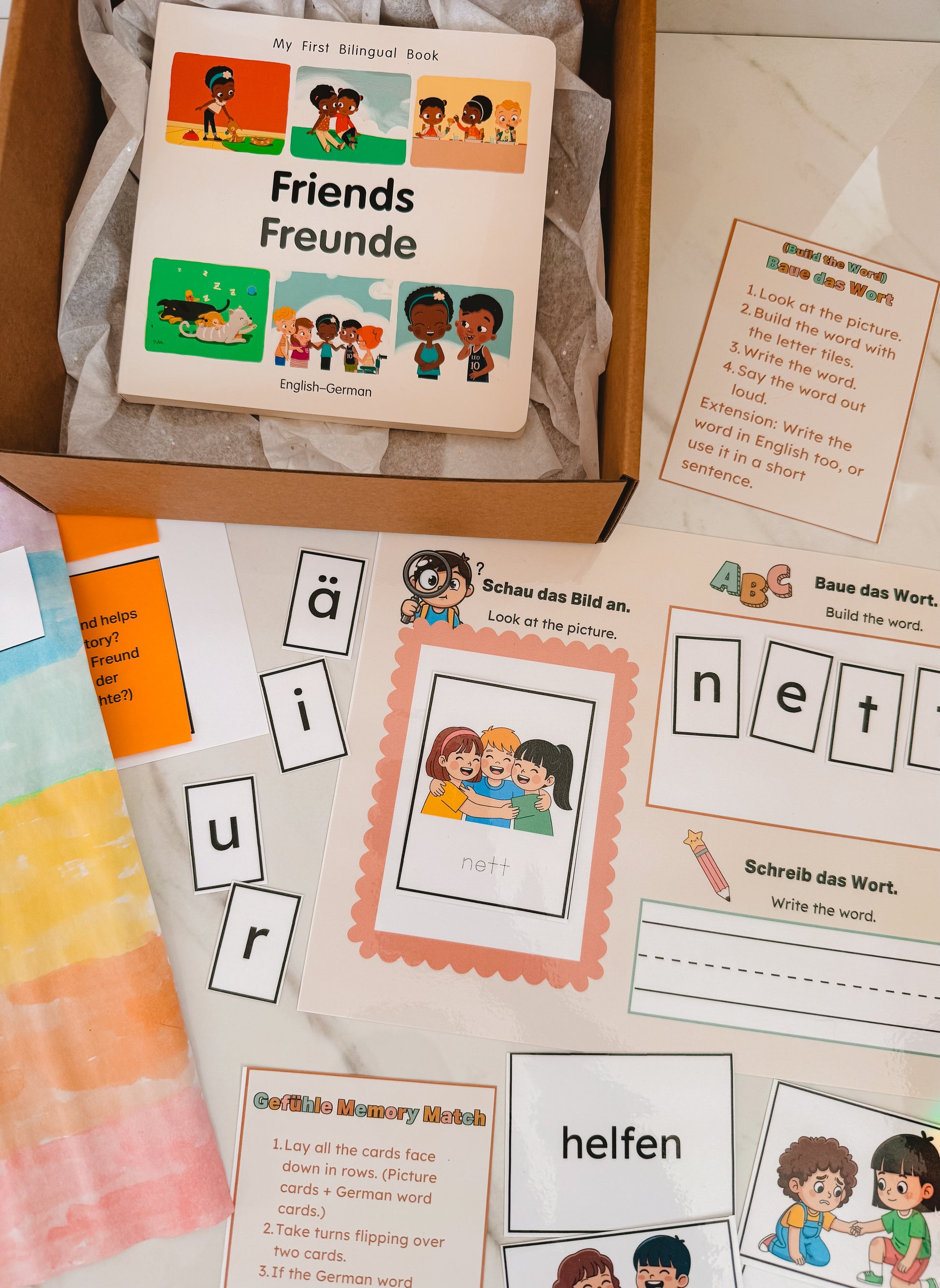 Educational materials including a book titled 'Friends Freunde' and flashcards in a box.